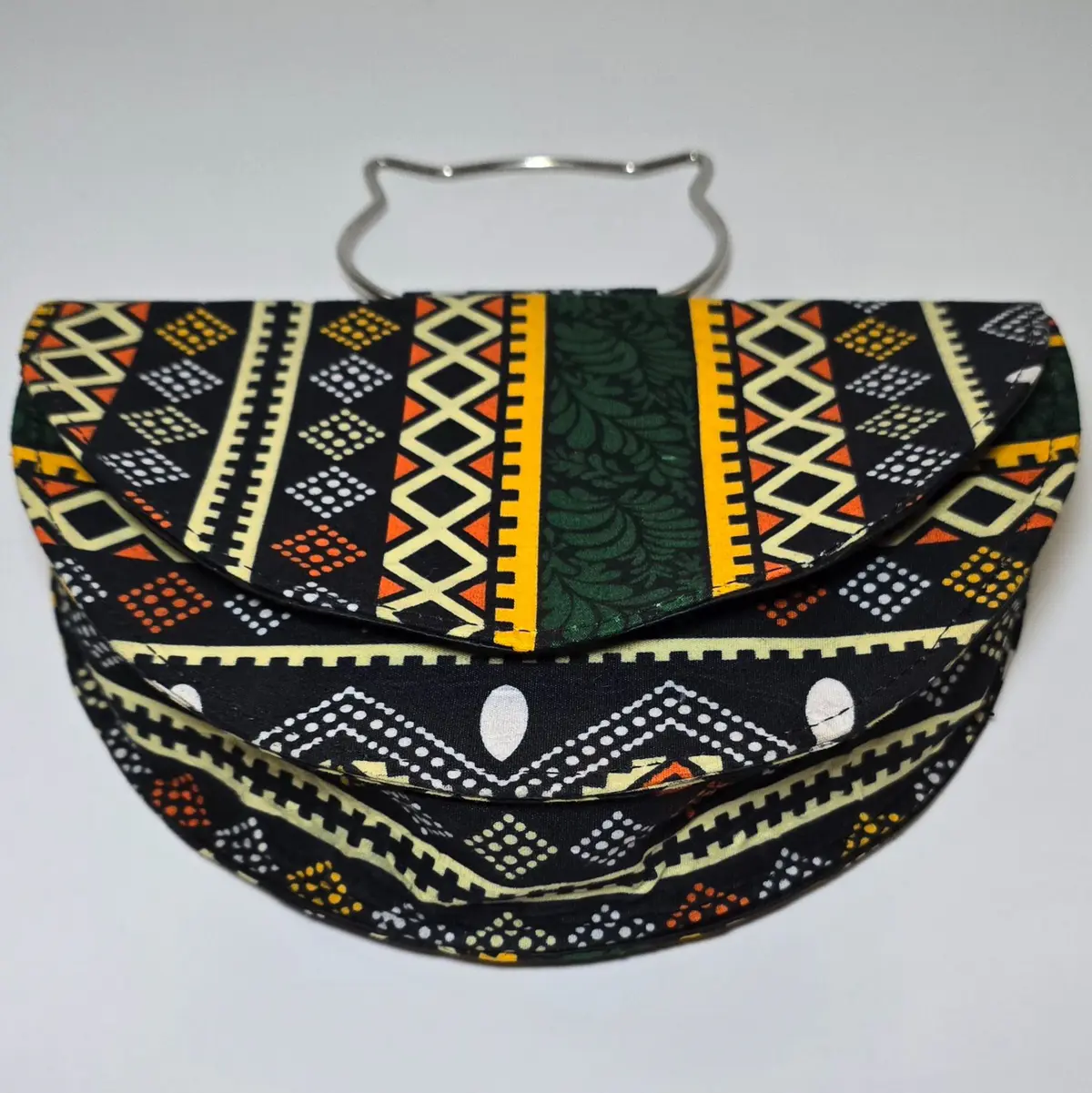 Front view of the Ankara-patterned clutch bag featuring bold, colorful geometric patterns and a cat-ear-shaped metal handle, highlighting its stylish design.
