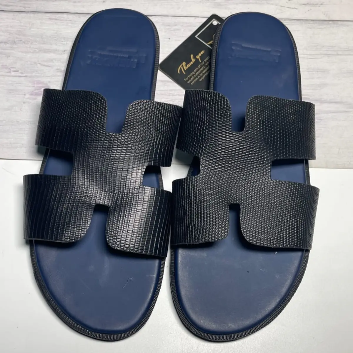 An elevated view of a pair of leather sliders.