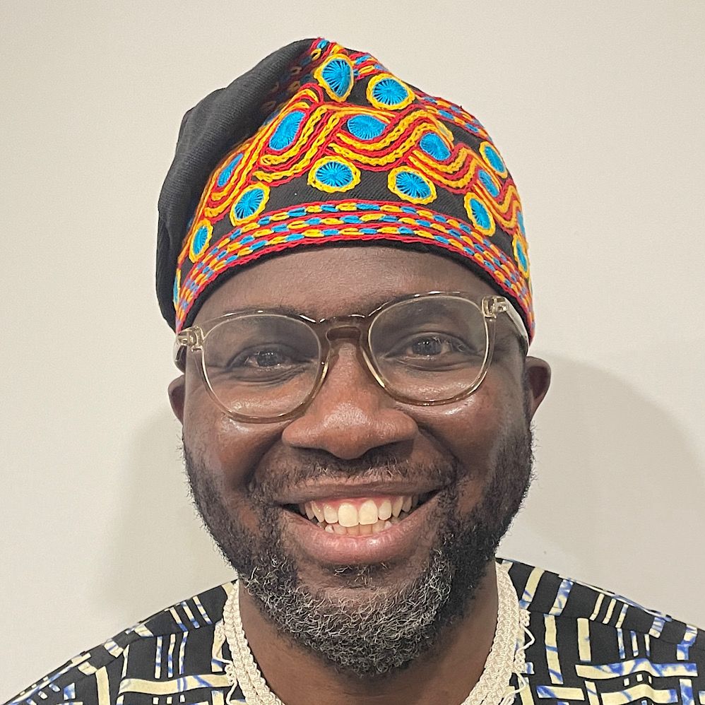 Black male wearing a traditional Aso Oke embroided cap