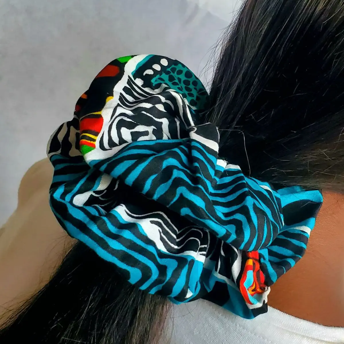 An image of an Ankara scrunchie holding a woman's hair.