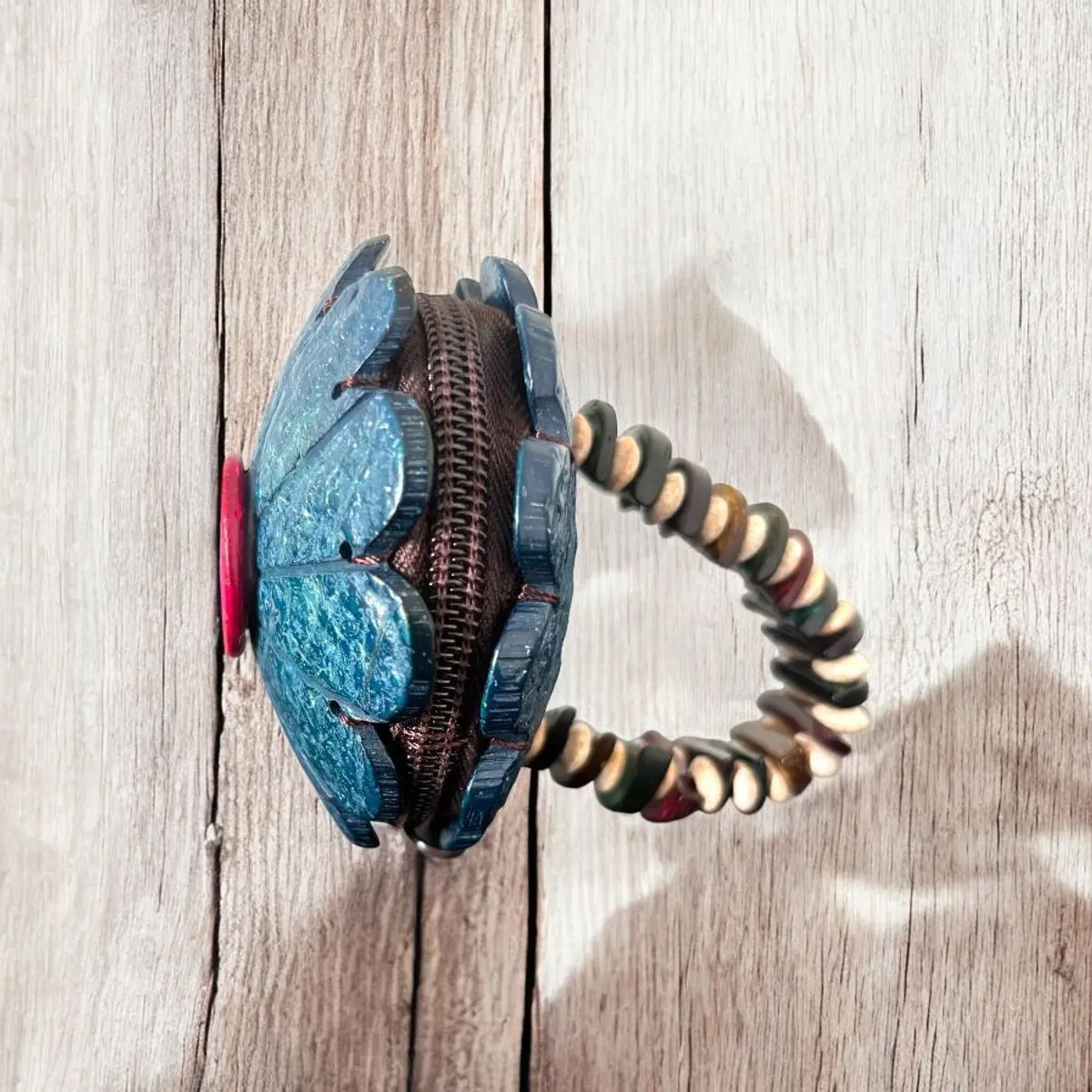 A sideview of a blue handmade wooden coin purse for kids