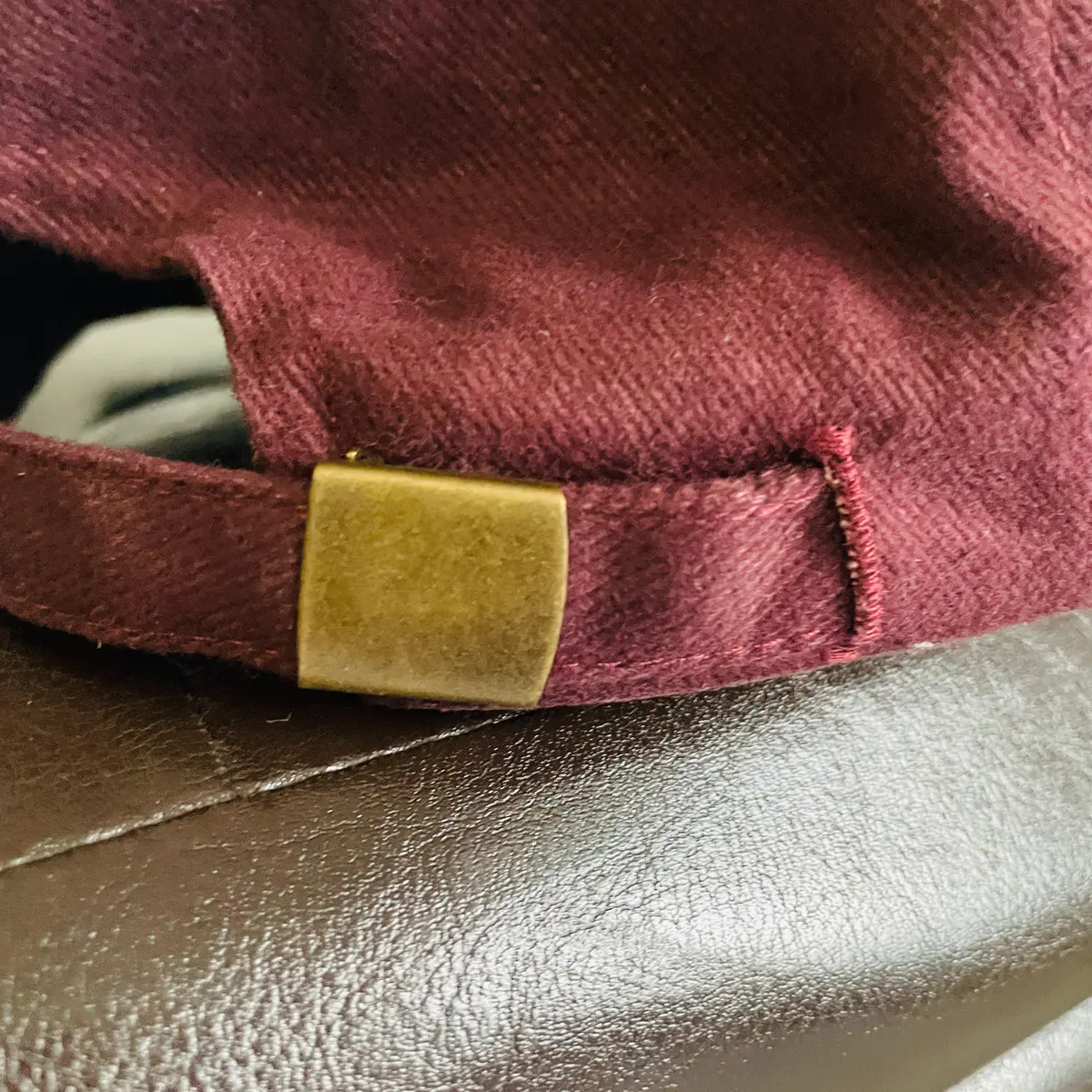 Back view of a burgundy baseball cap with the African map logo