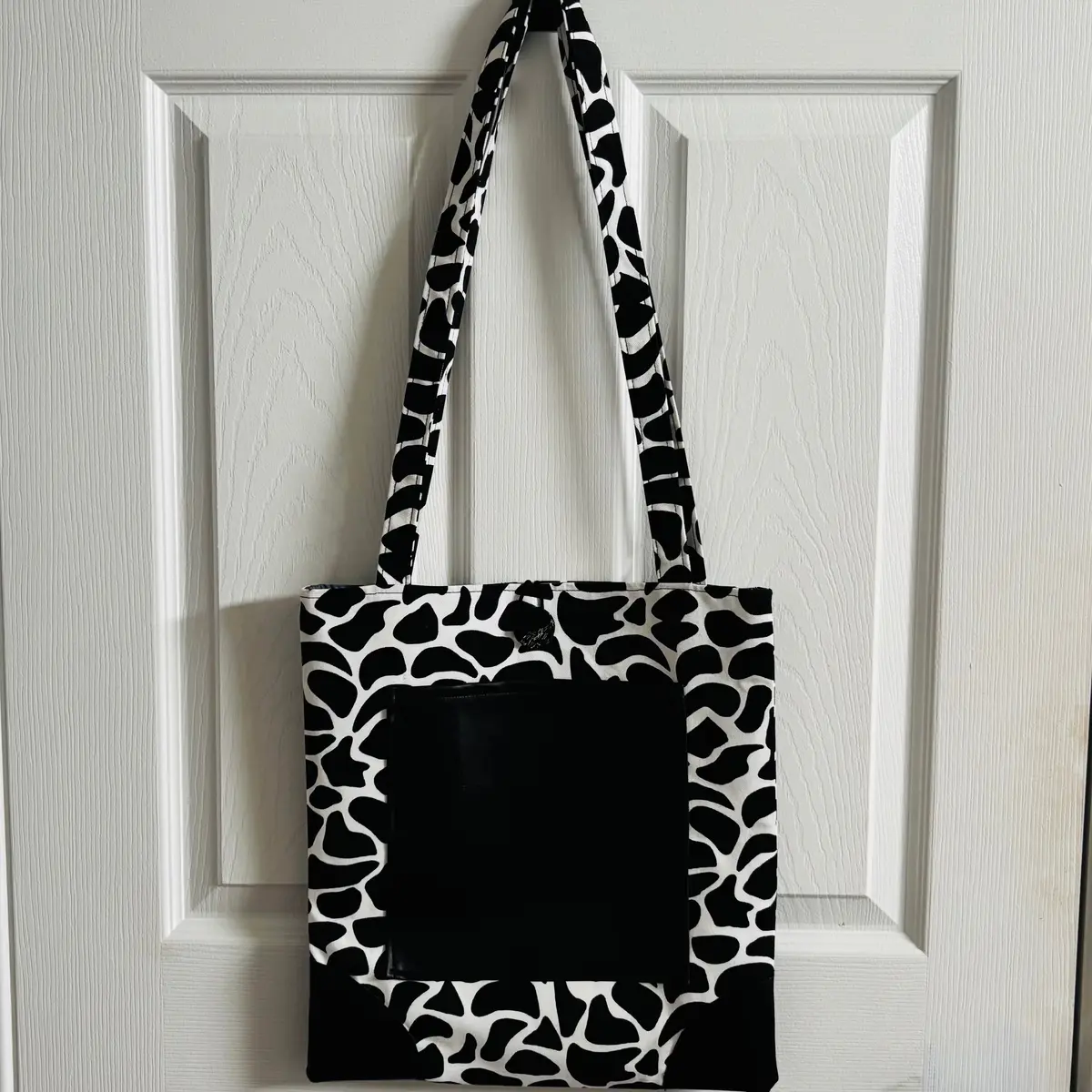 Front view of the black and white animal print tote bag