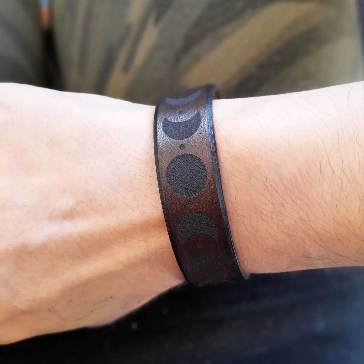 Moon phase leather bracelet worn on wrist