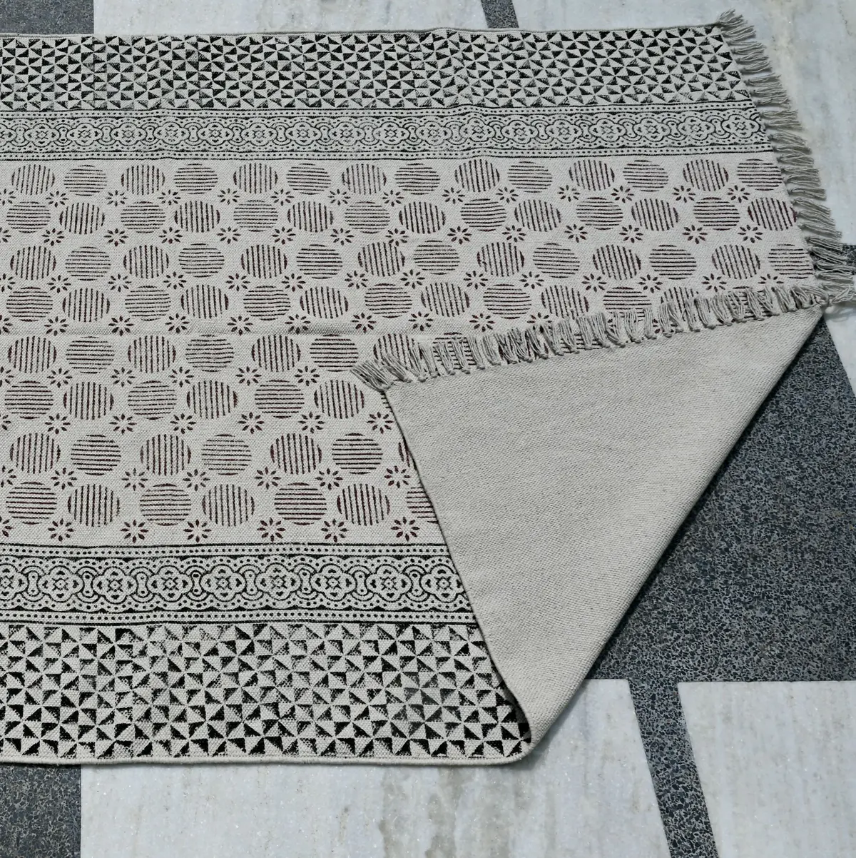 Block printed handmade Indian cotton rug for all block printing lovers. The area rugs are printed using eco-friendly dyes in traditional designs from India. Our handmade block print cotton rugs are skin friendly and manufactured using long lasting cotton fabric. With a neutral color and fashion forward patterns, these are pieces you can build a room around. This boho inspired cotton rug has a smooth finish, created by stamping wooden blocks onto the surface. Available from us at a remarkably affordable price, you can use it to decorate your Living Room, Bedroom, Office, Kitchen, Kids Area, Hallway, Entryway, Bathroom, and many more spaces.