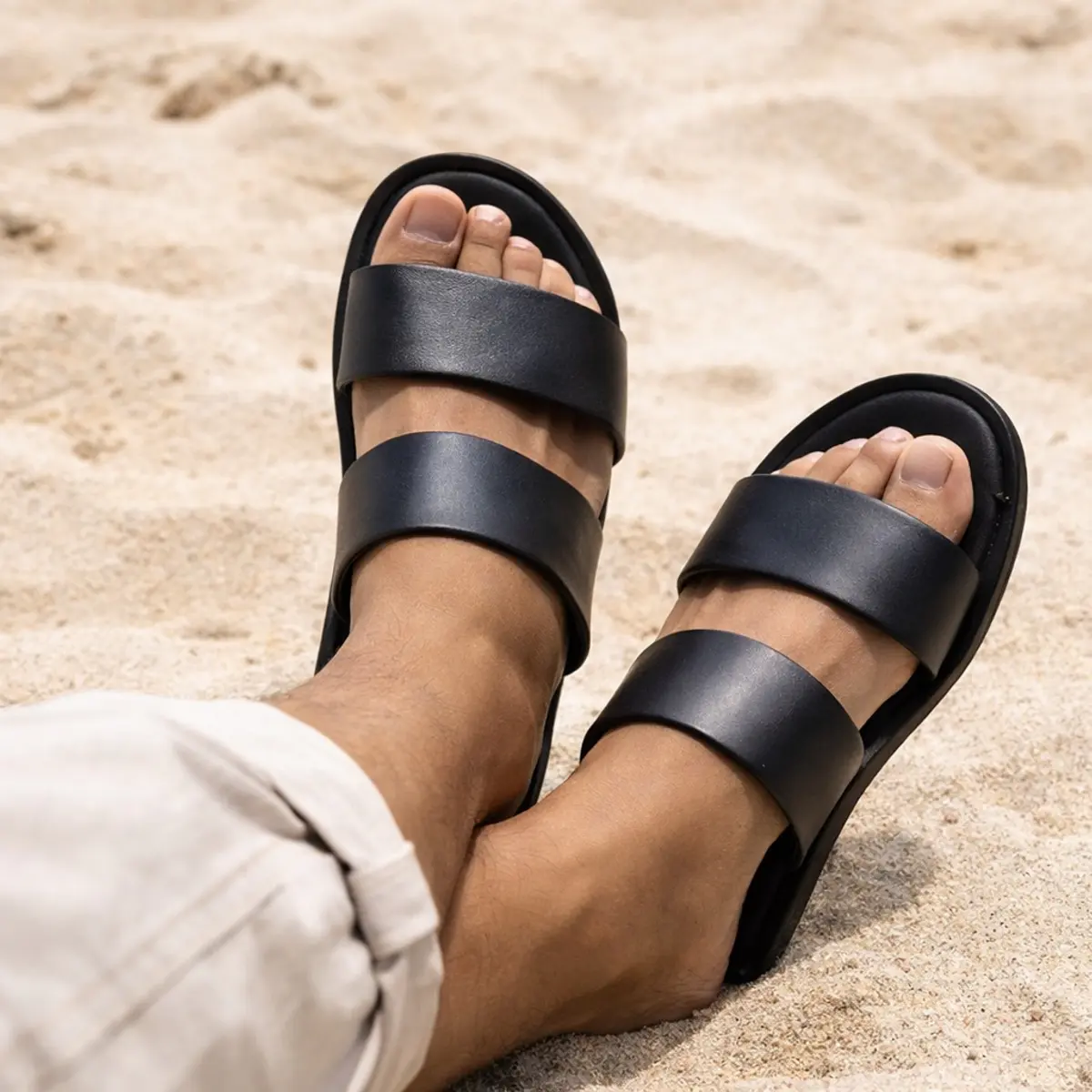 Unisex black double-strap slide sandals with open toe and minimalist design.