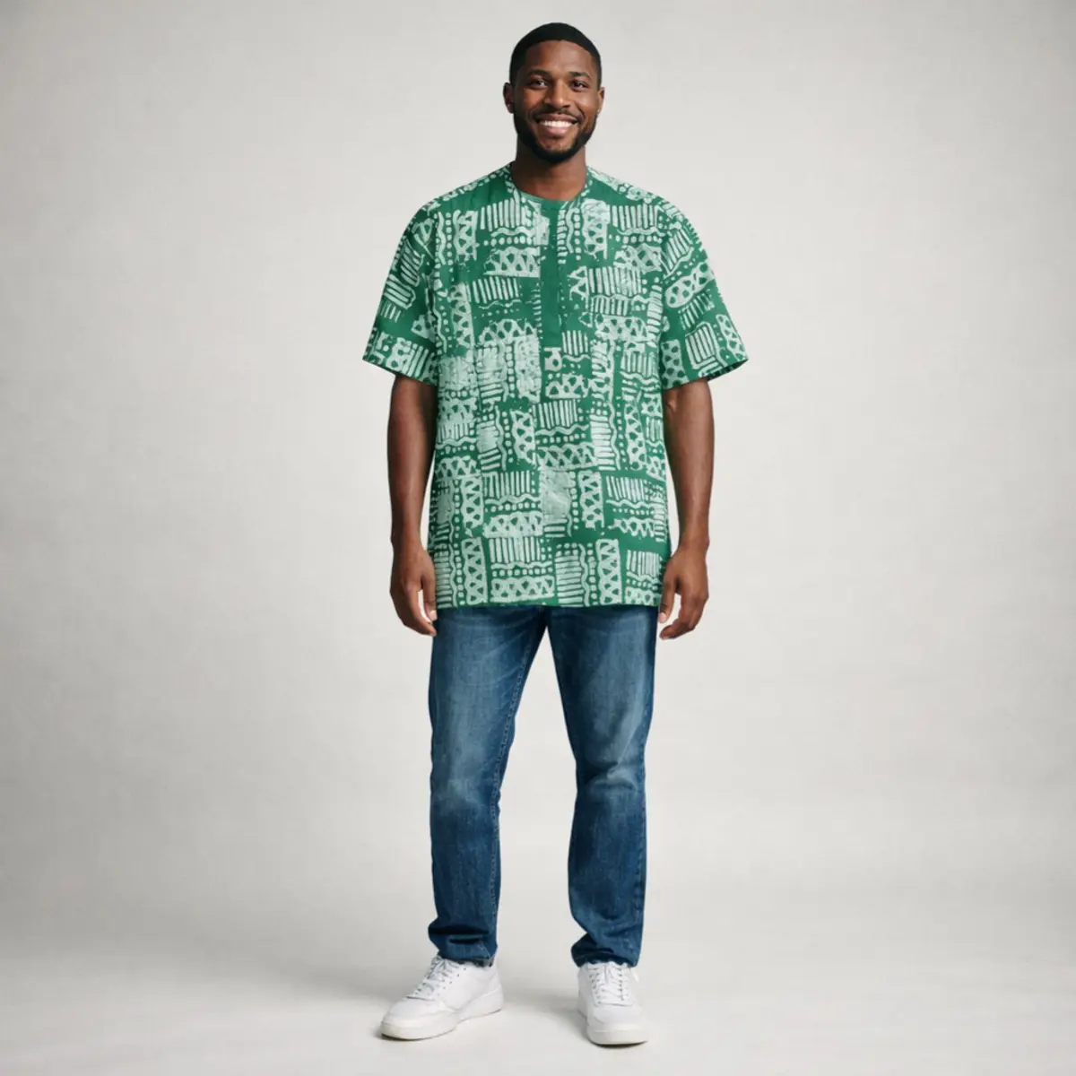 Green Adire short-sleeve top with traditional batik pattern, worn with blue jeans.