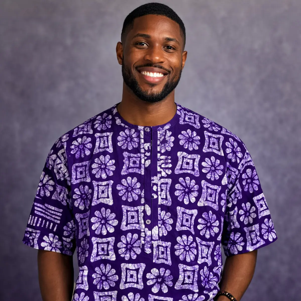 Purple Adire batik short-sleeve top with white geometric floral patterns.