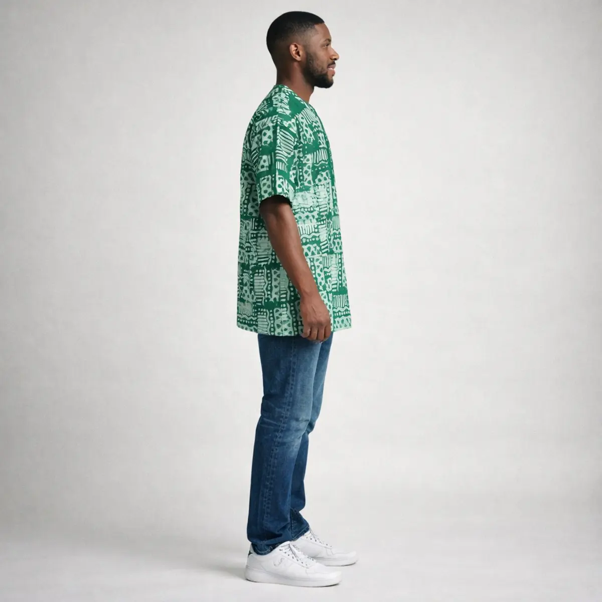 Green Adire short-sleeve top with traditional batik pattern, worn with blue jeans.