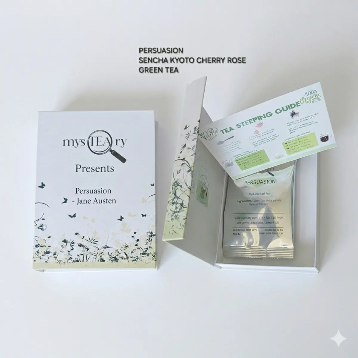 A white book-style gift box labeled 'mysTEAry Presents Persuasion — Jane Austen' sits open beside its lid, revealing a sealed foil pouch of 25g Persuasion loose leaf tea and a green and white tea steeping guide card with botanical illustrations. The packaging features soft white tones with green botanical artwork and butterfly motifs. Color: White, Green