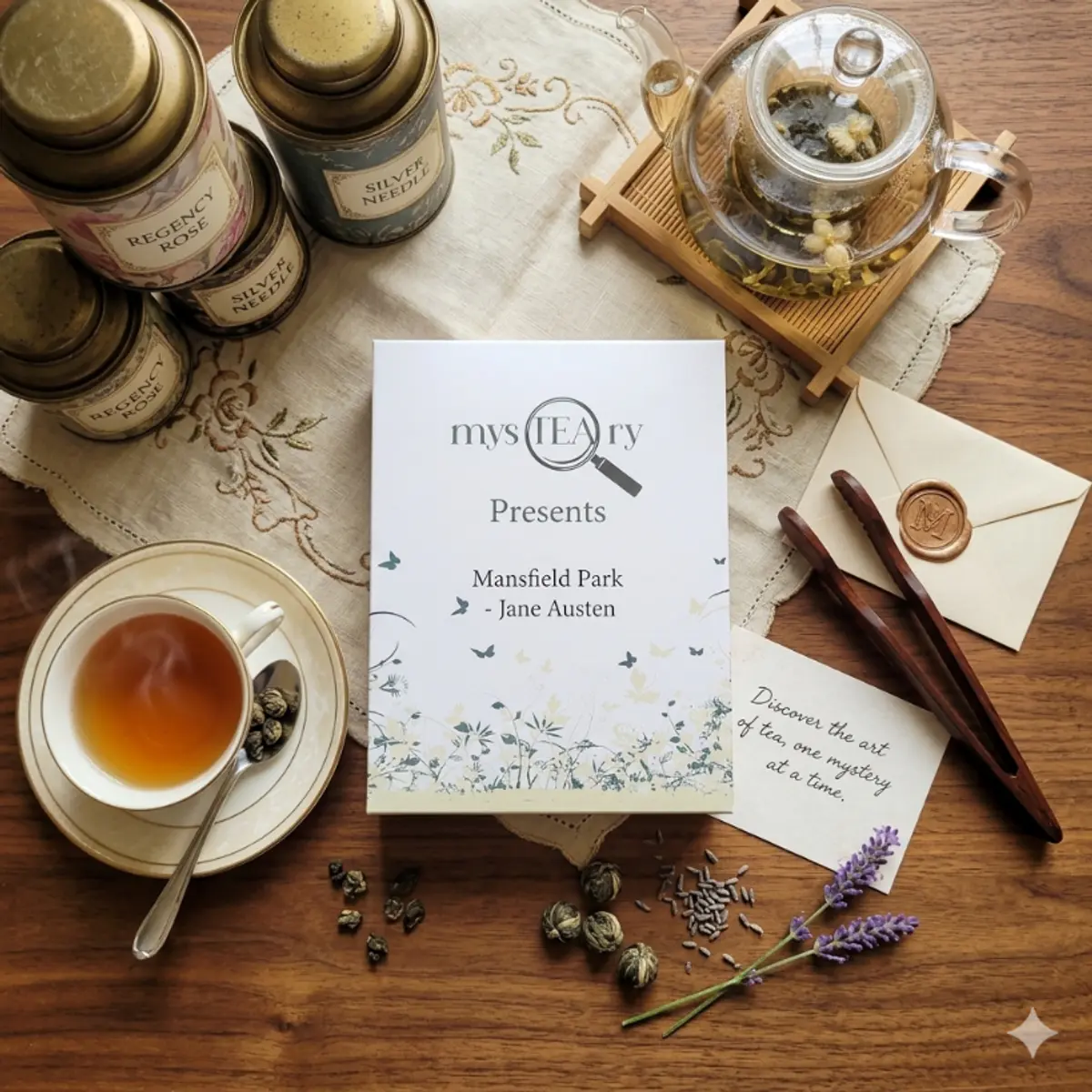 An elegant flat-lay of the mysTEAry Mansfield Park by Jane Austen tea gift box centered on a hand-embroidered linen runner, surrounded by gold-toned tins labeled Regency Rose and Silver Needle, blooming tea pearls, a glass teapot with florals, a wax-sealed envelope, hand-carved wooden tongs, a sprig of fresh lavender, and a handwritten note card reading 'Discover the art of tea, one mystery at a time.' Color: Antique Gold, Soft Blush Rose, and Lavender